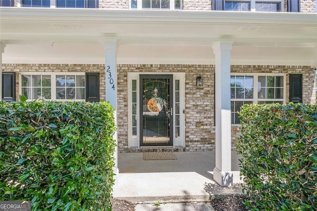 2304 Mitford Ct, Dacula, GA 30019 - doorway to property featuring a porch and brick siding