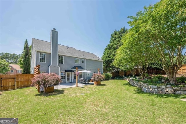 2304 Mitford Ct, Dacula, GA 30019 - back of property with a patio area and a chimney