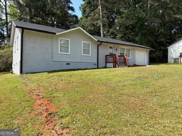 3339 Clevemont Ct, Ellenwood, GA 30294 - view of front of property with crawl space, a front yard, board and batten siding, an attached garage, and brick siding