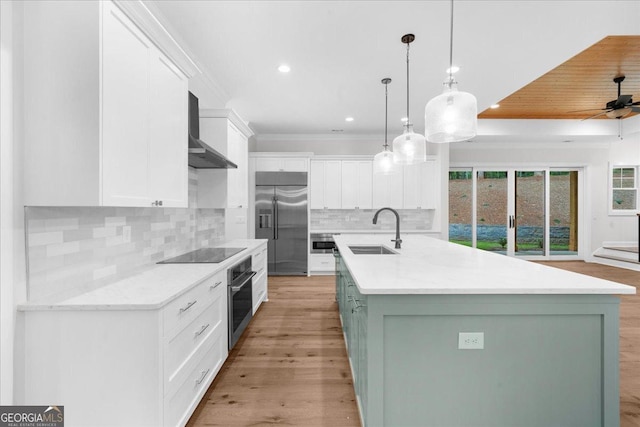 225 Laurel Place Dr, Cornelia, GA 30531 - kitchen featuring a sink, stainless steel appliances, wall chimney range hood, white cabinetry, and decorative backsplash