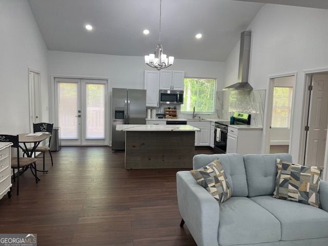 1757 Pineview Rd, Griffin, GA 30223 - kitchen with stainless steel appliances, wall chimney range hood, light countertops, a sink, and high vaulted ceiling
