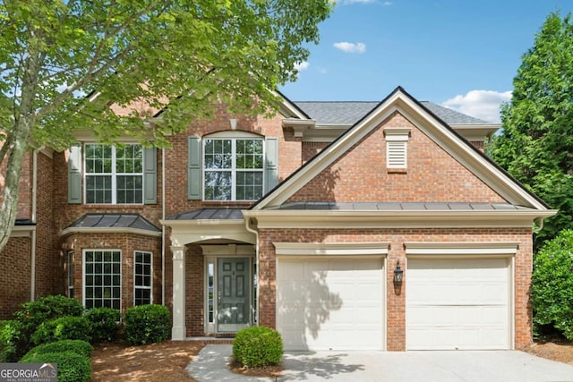 550 Mae Ln, Alpharetta, GA 30004 - view of front facade with concrete driveway, brick siding, an attached garage, and a standing seam roof