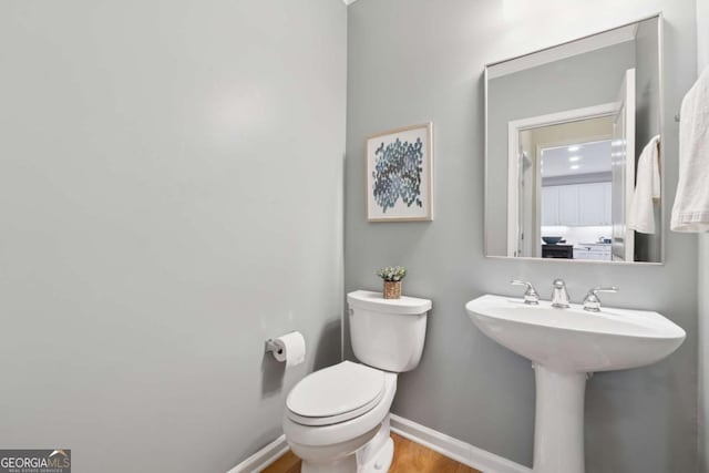 550 Mae Ln, Alpharetta, GA 30004 - half bathroom featuring toilet, baseboards, wood finished floors, and a sink