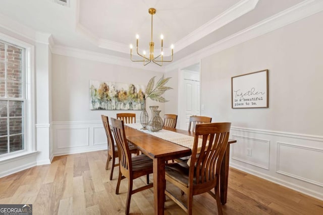 550 Mae Ln, Alpharetta, GA 30004 - dining area with a chandelier, light wood-style flooring, a decorative wall, a tray ceiling, and a wainscoted wall