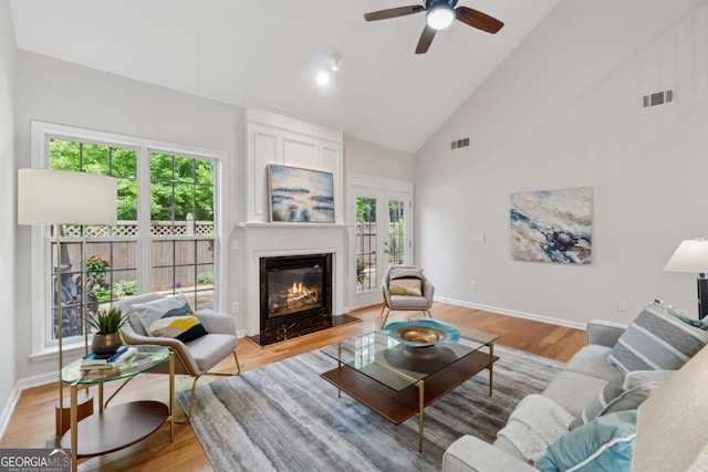 550 Mae Ln, Alpharetta, GA 30004 - living room featuring healthy amount of natural light, ceiling fan, a glass covered fireplace, high vaulted ceiling, and light wood-type flooring