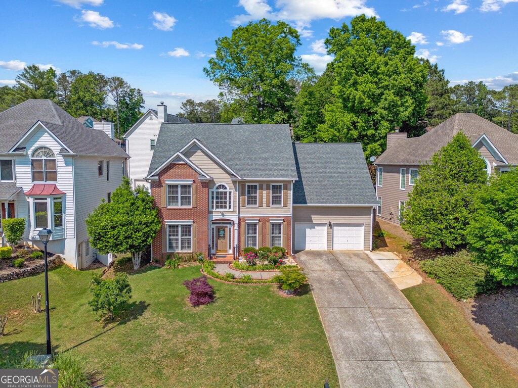 2325 Walnut Grove Way, Suwanee, GA 30024 - view of front of property with an attached garage, concrete driveway, brick siding, a front yard, and roof with shingles