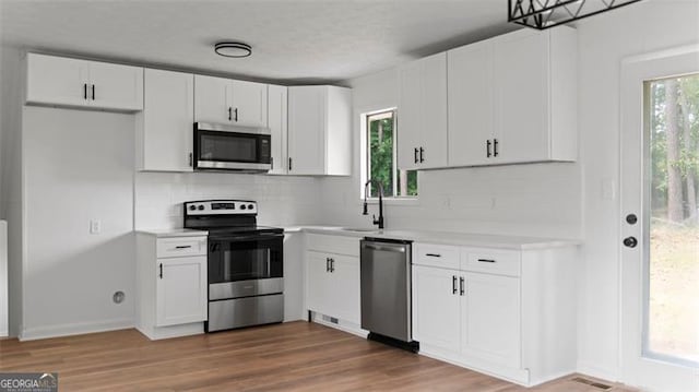 3735 Benchmark, Atlanta, GA 30349 - kitchen with stainless steel appliances, tasteful backsplash, light countertops, and white cabinets