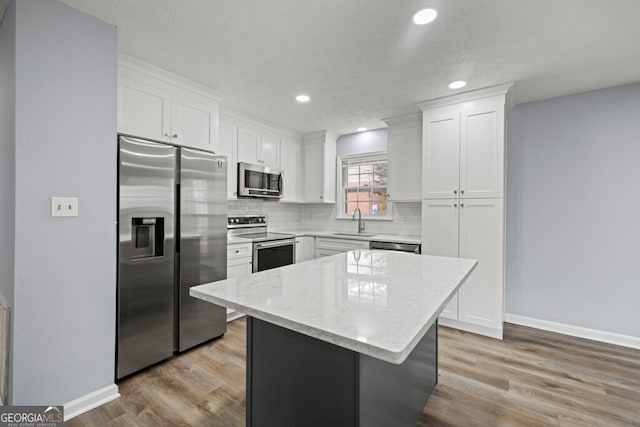 202 E 5th Ave, Winder, GA 30680 - kitchen with stainless steel appliances, white cabinets, a sink, decorative backsplash, and baseboards