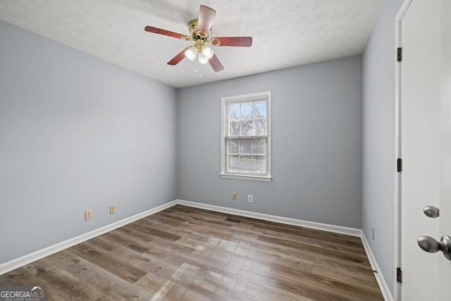 202 E 5th Ave, Winder, GA 30680 - spare room featuring wood finished floors, a ceiling fan, a textured ceiling, and baseboards