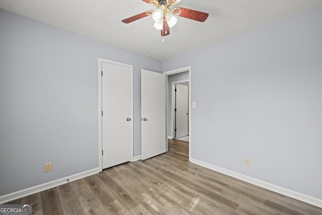 202 E 5th Ave, Winder, GA 30680 - unfurnished bedroom with wood finished floors, baseboards, and ceiling fan