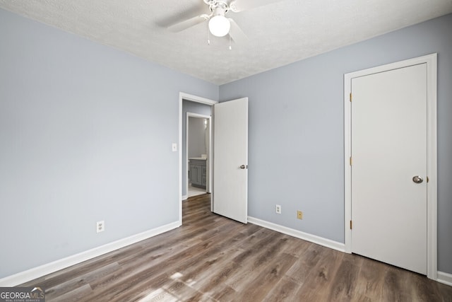 202 E 5th Ave, Winder, GA 30680 - unfurnished bedroom with wood finished floors, baseboards, a textured ceiling, and ceiling fan