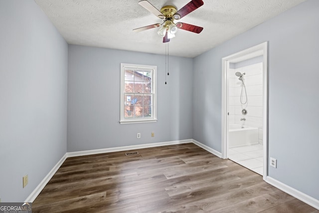 202 E 5th Ave, Winder, GA 30680 - empty room with ceiling fan, wood finished floors, a textured ceiling, and baseboards