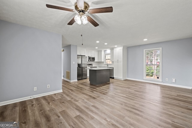 202 E 5th Ave, Winder, GA 30680 - unfurnished living room featuring recessed lighting, light wood-type flooring, a ceiling fan, baseboards, and a textured ceiling