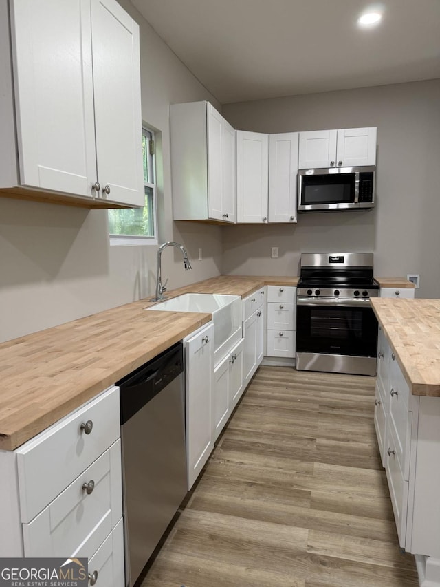1300 Murphy Ave, Lagrange, GA 30240 - kitchen featuring appliances with stainless steel finishes, butcher block countertops, a sink, white cabinetry, and recessed lighting