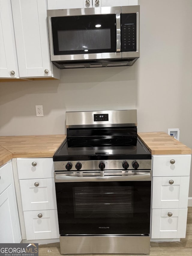 1300 Murphy Ave, Lagrange, GA 30240 - kitchen with appliances with stainless steel finishes, wooden counters, white cabinetry, and light wood-type flooring