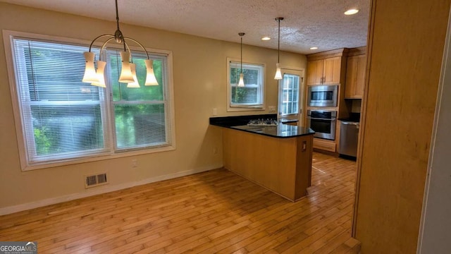 3246 Able Ct, Marietta, GA 30062 - kitchen featuring stainless steel appliances, a textured ceiling, a chandelier, a peninsula, and dark countertops