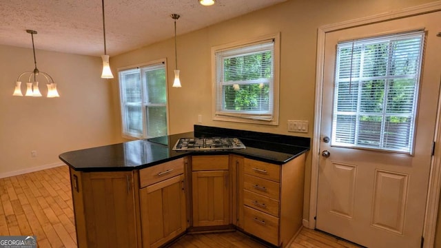 3246 Able Ct, Marietta, GA 30062 - kitchen featuring a chandelier, healthy amount of natural light, a textured ceiling, dark countertops, and a peninsula