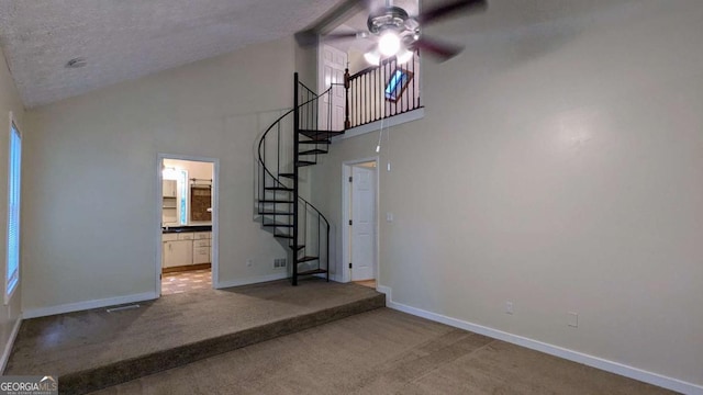 3246 Able Ct, Marietta, GA 30062 - unfurnished living room with ceiling fan, high vaulted ceiling, stairway, carpet floors, and a textured ceiling