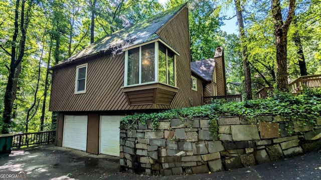 3246 Able Ct, Marietta, GA 30062 - view of side of home featuring a chimney, an attached garage, and asphalt driveway