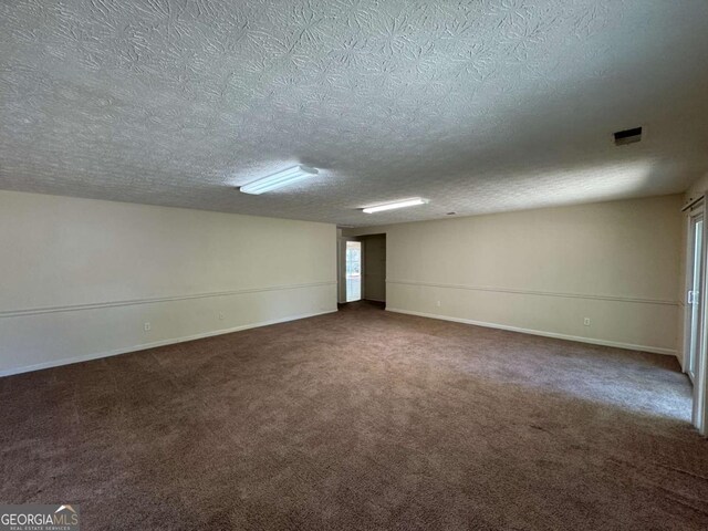 120 Squirrel Way, Atlanta, GA 30349 - unfurnished room featuring a textured ceiling and dark colored carpet