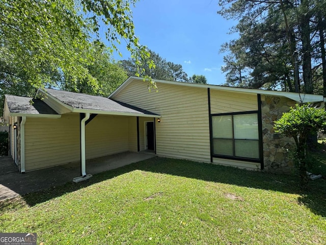 120 Squirrel Way, Atlanta, GA 30349 - rear view of property with a lawn and stone siding