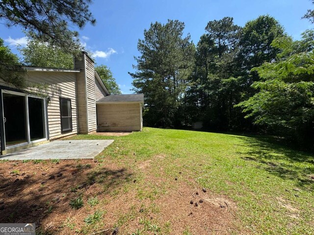 120 Squirrel Way, Atlanta, GA 30349 - view of grassy yard featuring a patio