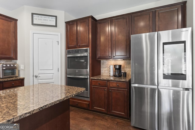 237 Parc Dr, Canton, GA 30114 - kitchen featuring stainless steel appliances, dark stone countertops, dark wood-style floors, and tasteful backsplash