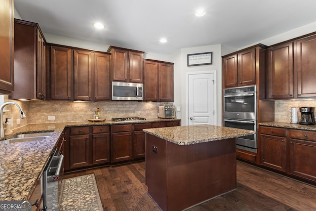 237 Parc Dr, Canton, GA 30114 - kitchen with appliances with stainless steel finishes, dark wood finished floors, decorative backsplash, stone counters, and a center island