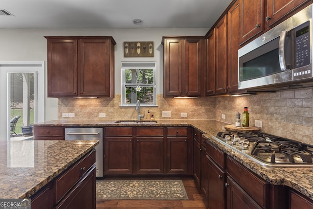 237 Parc Dr, Canton, GA 30114 - kitchen featuring stainless steel appliances, dark stone counters, backsplash, and dark wood finished floors