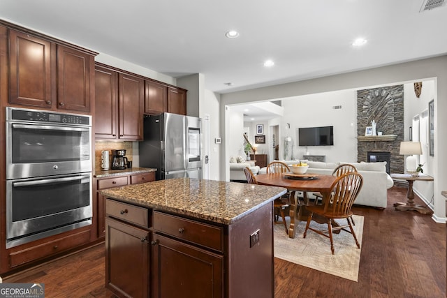 237 Parc Dr, Canton, GA 30114 - kitchen featuring stainless steel appliances, a fireplace, dark wood-type flooring, a center island, and recessed lighting