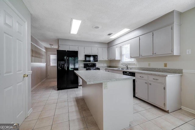 1282 Long Bridge Rd, Rincon, GA 31326 - kitchen with black appliances, light countertops, light tile patterned flooring, a center island, and a textured ceiling