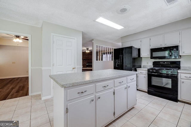 1282 Long Bridge Rd, Rincon, GA 31326 - kitchen featuring black appliances, a ceiling fan, light tile patterned floors, light countertops, and a kitchen island