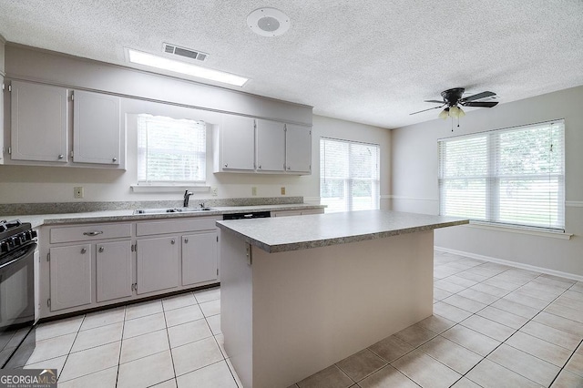 1282 Long Bridge Rd, Rincon, GA 31326 - kitchen with a sink, black gas range, light tile patterned floors, plenty of natural light, and a textured ceiling