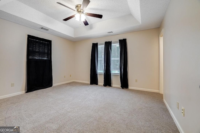 1282 Long Bridge Rd, Rincon, GA 31326 - empty room with a textured ceiling, carpet flooring, a raised ceiling, a ceiling fan, and baseboards