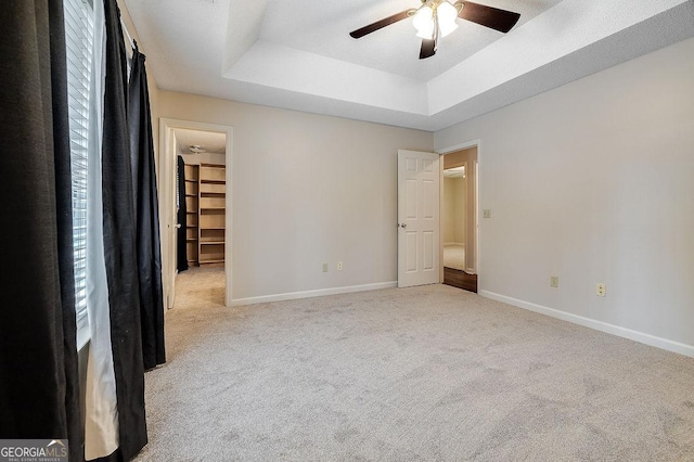 1282 Long Bridge Rd, Rincon, GA 31326 - unfurnished bedroom featuring carpet flooring, a raised ceiling, baseboards, a spacious closet, and a ceiling fan