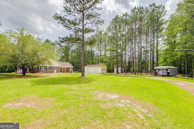 1282 Long Bridge Rd, Rincon, GA 31326 - view of green lawn featuring a detached garage, an outbuilding, and view of scattered trees
