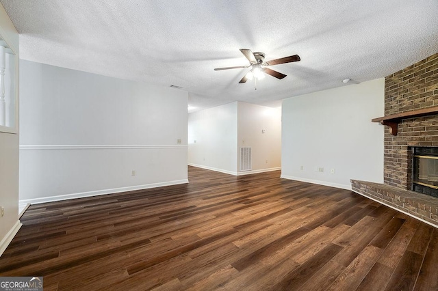 1282 Long Bridge Rd, Rincon, GA 31326 - unfurnished living room featuring a ceiling fan, wood finished floors, a textured ceiling, a brick fireplace, and baseboards