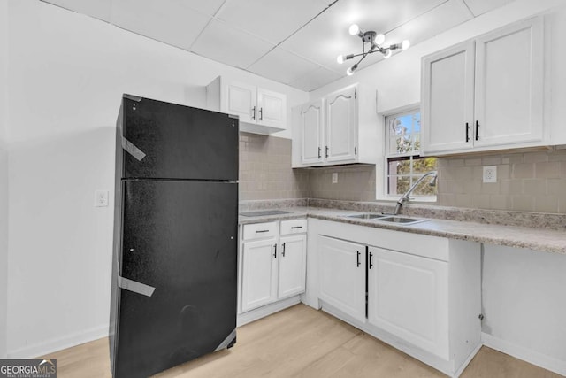 510 Edgewood Ave, Macon, GA 31201 - kitchen featuring freestanding refrigerator, white cabinetry, light countertops, decorative backsplash, and light wood-style flooring