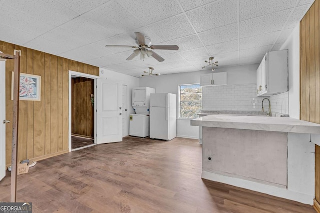 510 Edgewood Ave, Macon, GA 31201 - kitchen featuring freestanding refrigerator, estacked washer and dryer, ceiling fan, wooden walls, and a peninsula