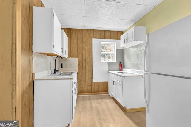 510 Edgewood Ave, Macon, GA 31201 - kitchen featuring freestanding refrigerator, light countertops, light wood finished floors, wood walls, and white cabinetry