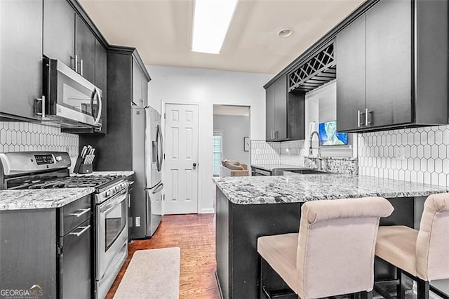 2865 Winter Rose, Dunwoody, GA 30360 - kitchen with appliances with stainless steel finishes, tasteful backsplash, a peninsula, and dark cabinetry