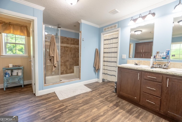 3251 Harrell Rd, Whigham, GA 39897 - full bath with wood finished floors, double vanity, a stall shower, ornamental molding, and plenty of natural light