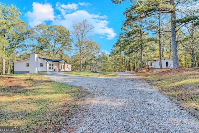 580 Vaughn Rd, Griffin, GA 30223 - view of property exterior with gravel driveway, a chimney, and a yard