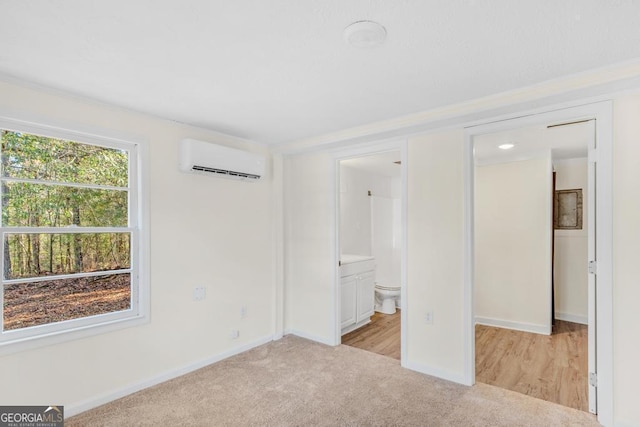 580 Vaughn Rd, Griffin, GA 30223 - unfurnished bedroom featuring an AC wall unit, light carpet, baseboards, and ensuite bath