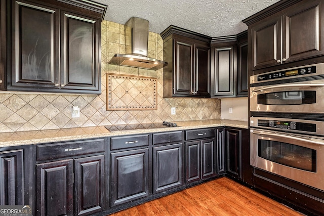 68 Riveree Rd, Brooks, GA 30205 - kitchen with wall chimney range hood, stainless steel double oven, light wood-type flooring, black electric cooktop, and tasteful backsplash