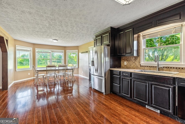 68 Riveree Rd, Brooks, GA 30205 - kitchen with stainless steel fridge, dark wood-type flooring, backsplash, dishwasher, and dark cabinets
