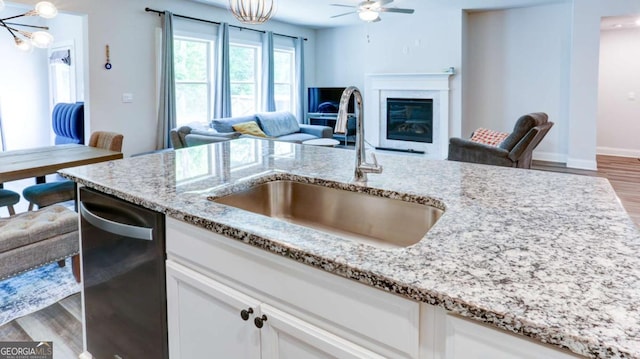 3410 Summerpoint Xing, Cumming, GA 30028 - kitchen featuring a sink, open floor plan, stainless steel dishwasher, a chandelier, and light stone counters