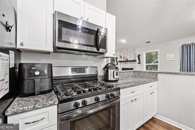 10650 Colony Glen Dr, Johns Creek, GA 30022 - kitchen with stainless steel appliances, white cabinetry, light stone countertops, and dark wood-style floors