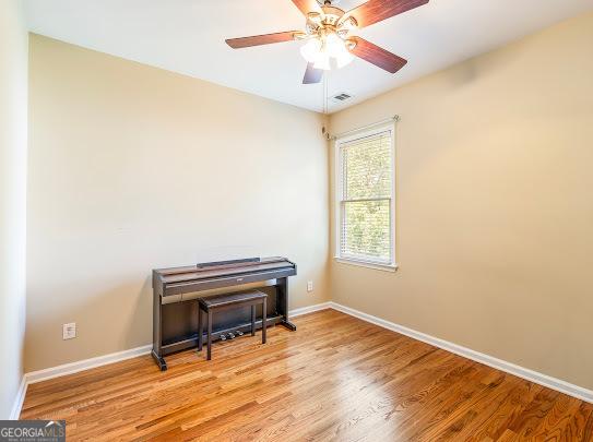 2810 Promenade Pl, Buford, GA 30519 - empty room featuring light wood finished floors, baseboards, and ceiling fan
