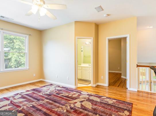 2810 Promenade Pl, Buford, GA 30519 - unfurnished bedroom featuring light wood-type flooring, baseboards, ensuite bath, and a ceiling fan